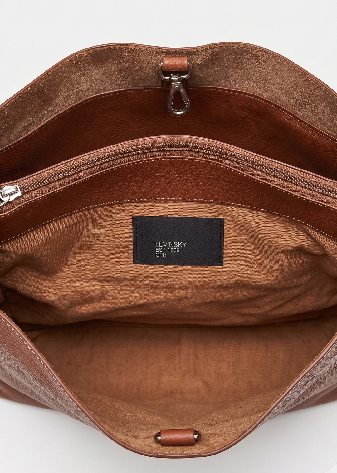 Open view of a brown leather bag showing the interior, with a black brand label reading 'LEVINSKY 