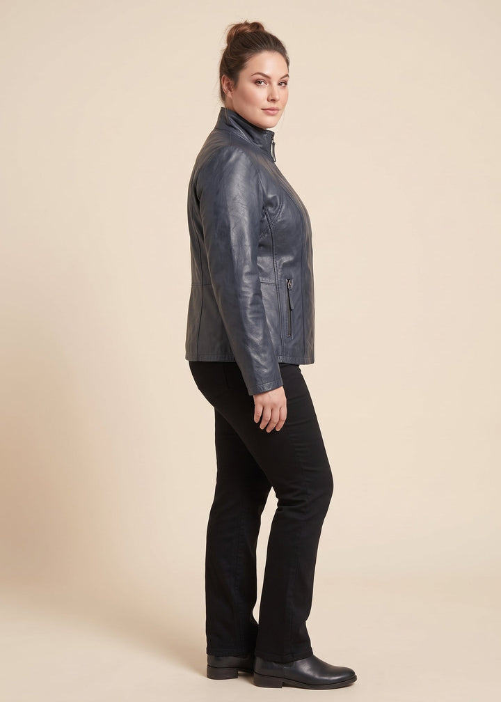 A woman modeling a navy real leather jacket, shown in profile against a solid beige studio background.